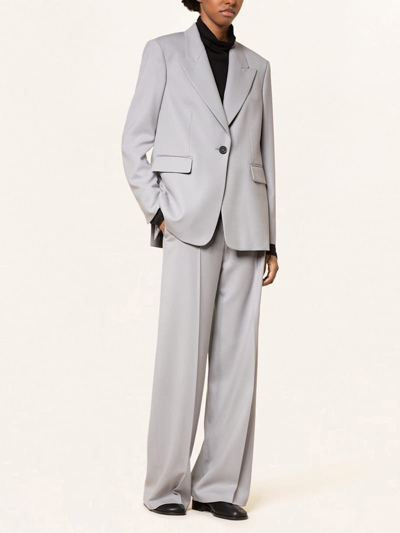 Frau trägt hellgrauen Hosenanzug