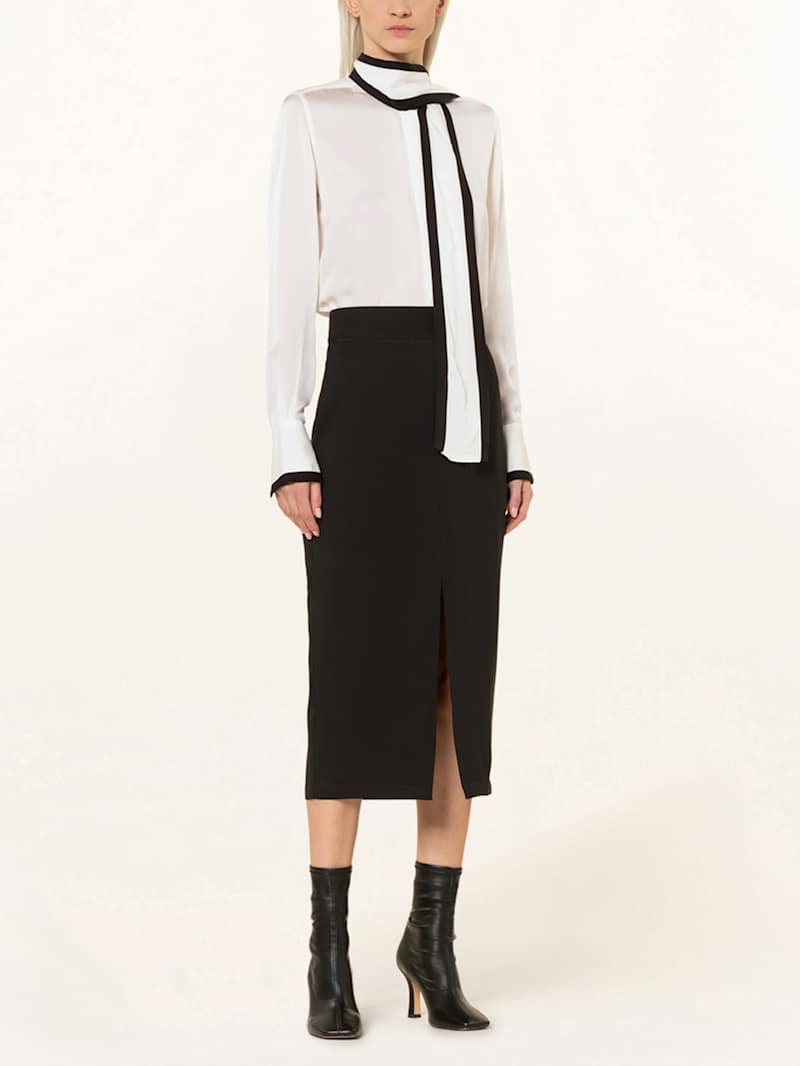 Frau trägt weiße Bluse mit schwarzem Bleistiftrock