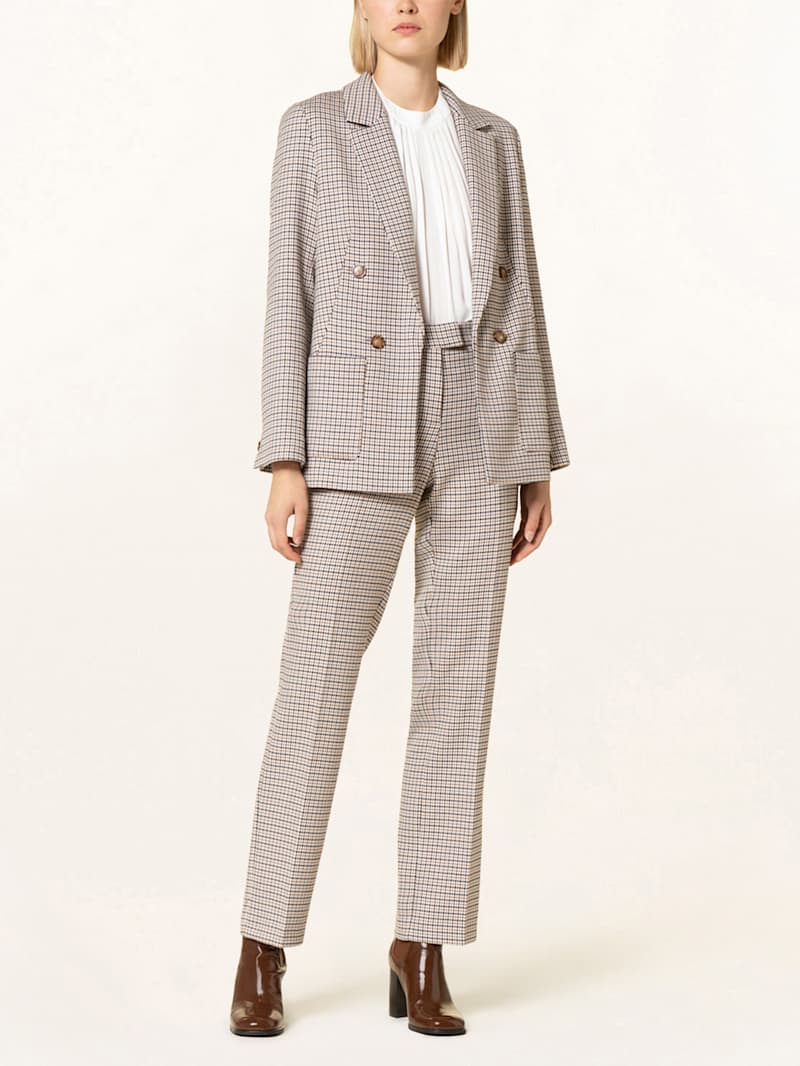 Frau trägt Blazer und Hose mit Muster