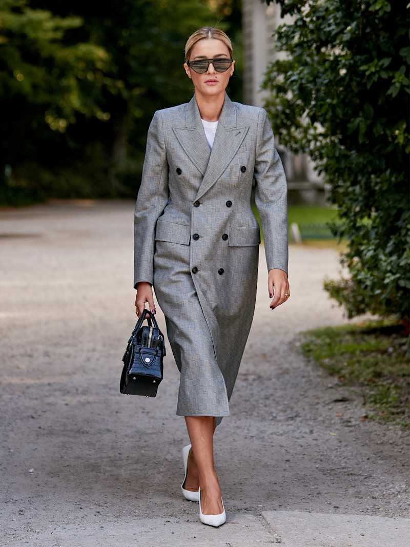 Blonde Frau trägt graues Kleid im Blazer-Stil