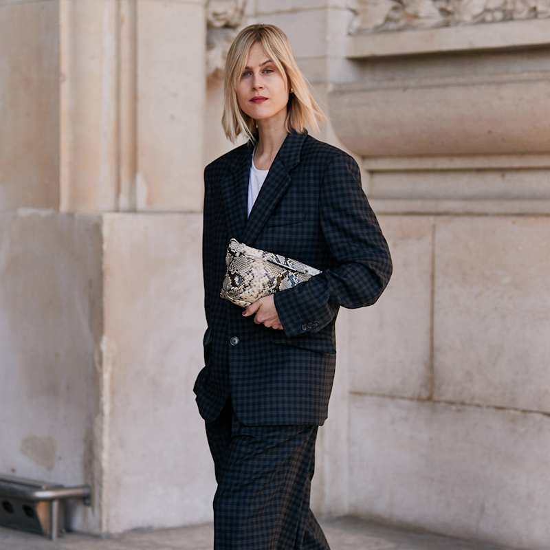 Blonde Frau trägt dunkelblau gemusterte Business-Kombination