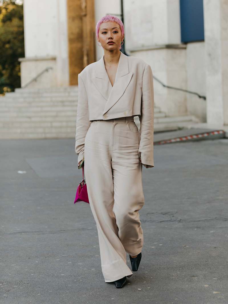 Frau mit pinken Haaren trägt Leinen-Blazer und Leinen-Hose in Beige