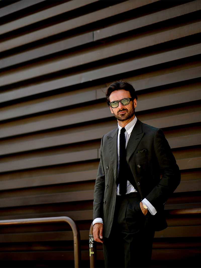 Mann trägt als Business Attire Look einen grauen Anzug mit Krawatte