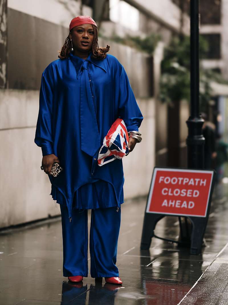 Frau trägt tonalen Look in der Farbe Blau und eine Tasche mit Union Jack-Print