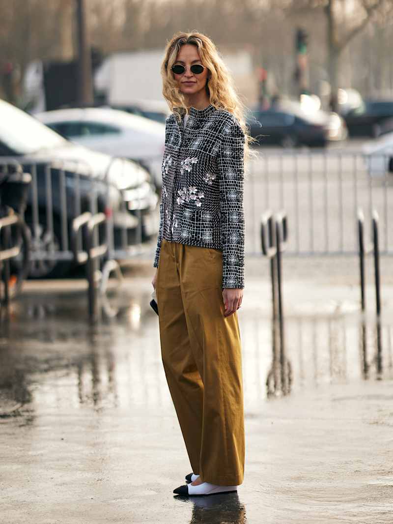 Frau trägt eine Tweed-Jacke zur Stoffhose