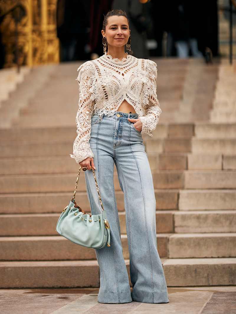 Frau trägt Spitzen-Oberteil und Flared-Leg-Jeans