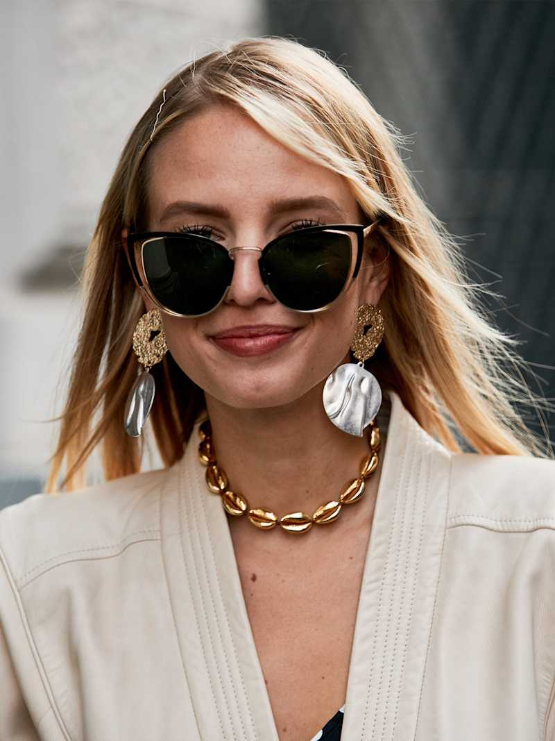 Blonde Frau mit kühlem Hauttyp trägt dunkle Cateye-Sonnenbrille