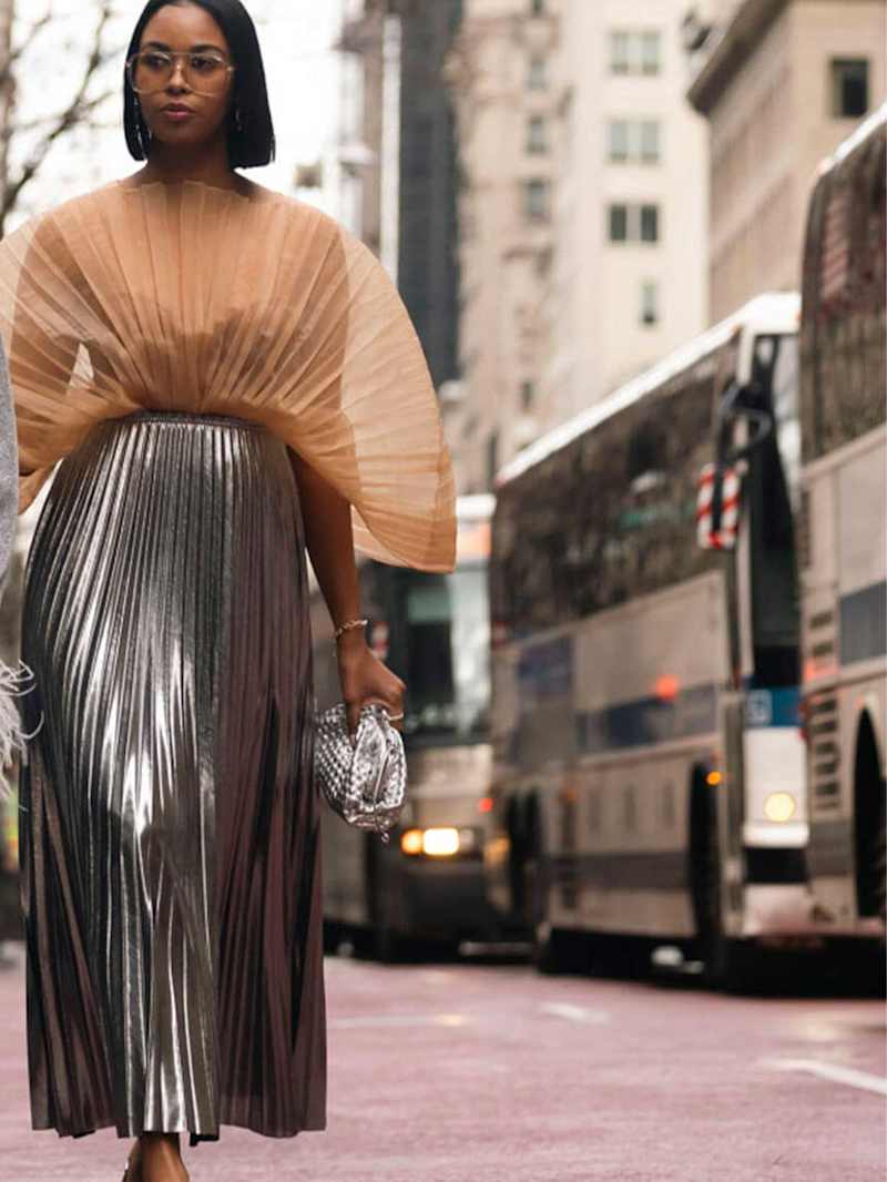 Frau trägt einen silbernen Plisseerock