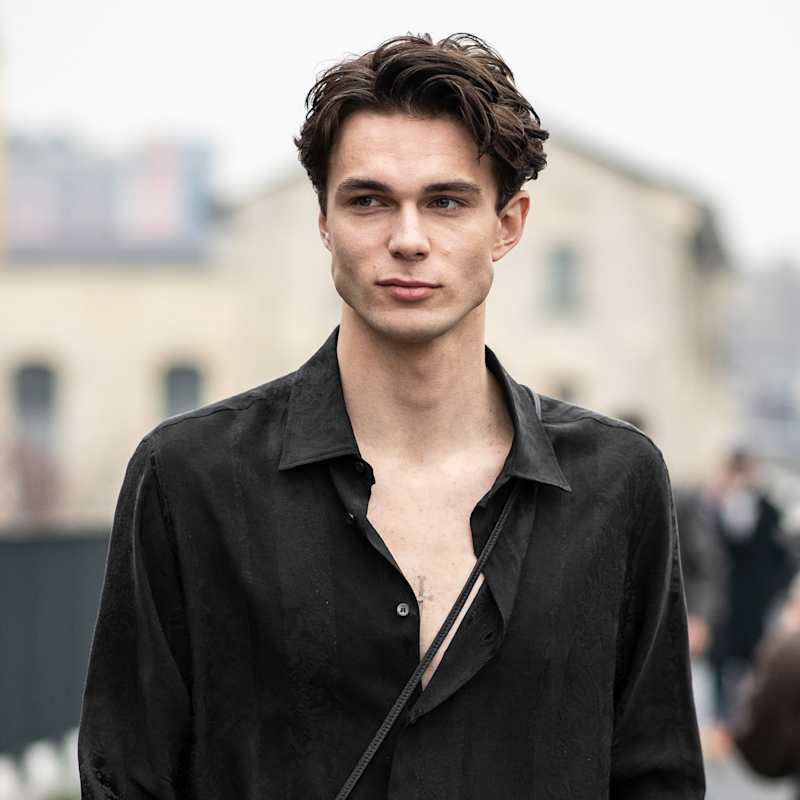 Brünetter Mann mit eckiger Gesichtsform und schwarzem Hemd