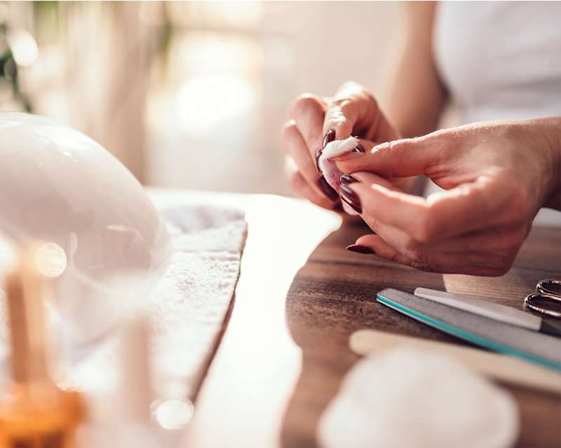 Frau pflegt sich ihre dunkelrot lackierten Nägel