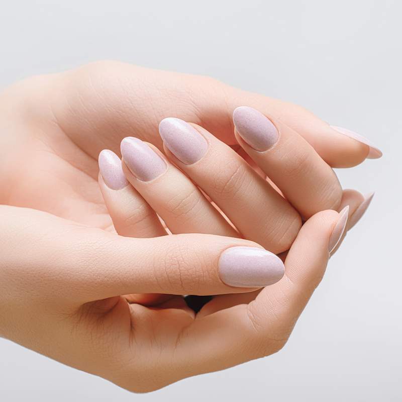 Zwei Hände mit nudefarbener Maniküre