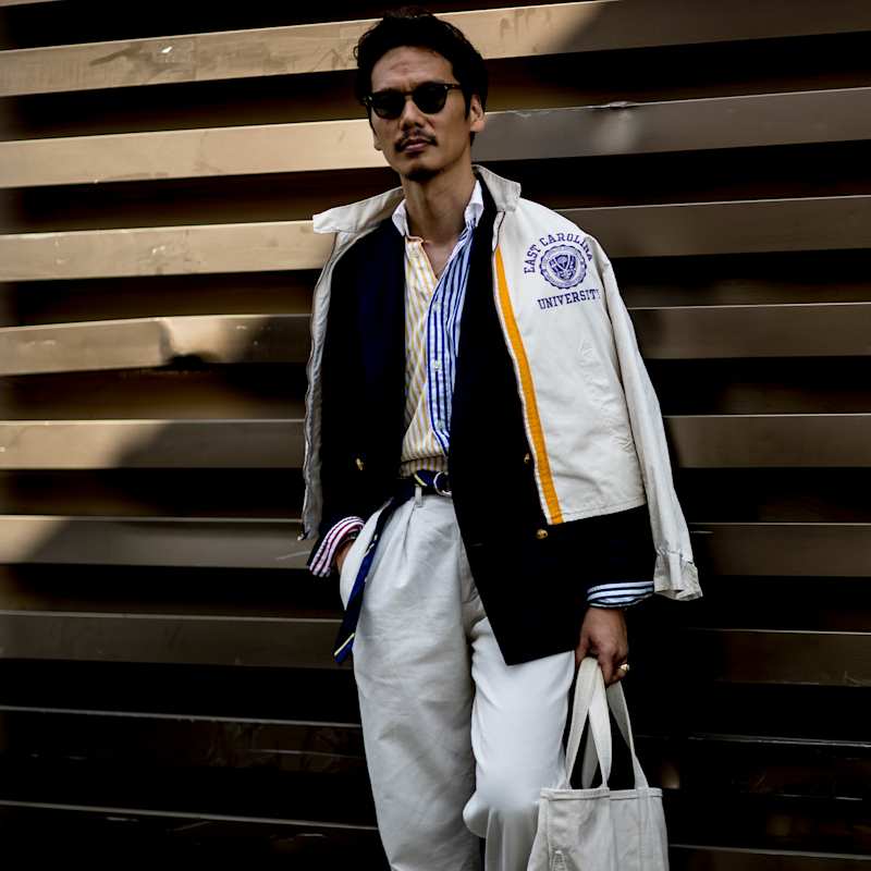 Mann trägt Collegejacke über Sakko und Hemd