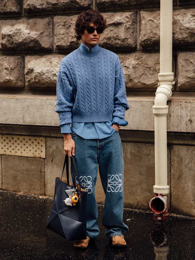 Mann trägt blauen Strickpullover zu einer Jeans