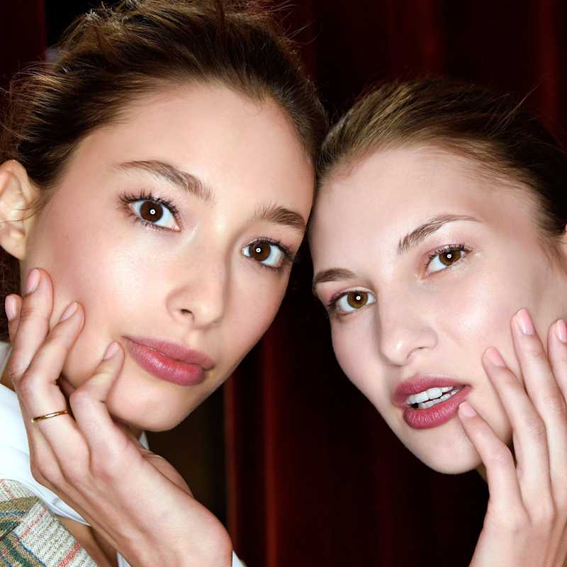 Zwei Frauen tragen eine rosafarbene Maniküre