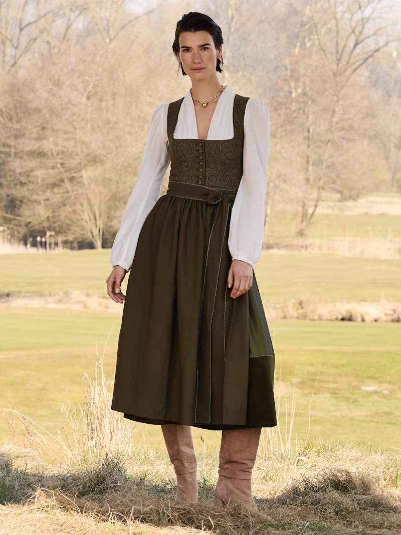 Brünette Frau trägt Dirndl in Erdtönen und weisse Dirndlbluse