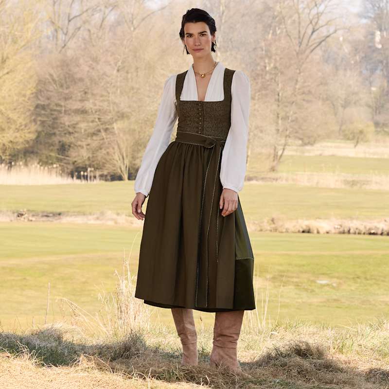 Brünette Frau trägt Dirndl in Erdtönen und weisse Dirndlbluse