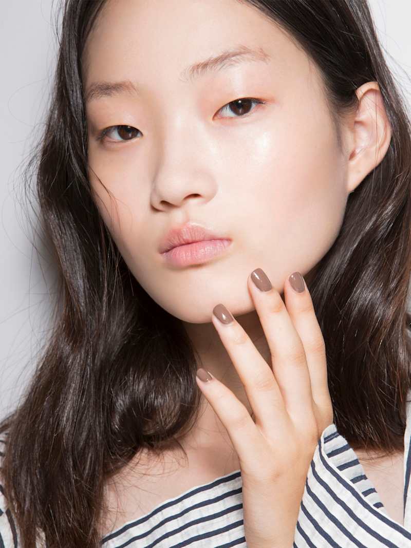 Brünette Frau trägt Maniküre in Hellbraun