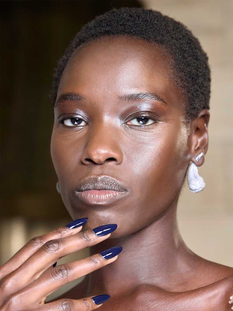 Dunkelhaarige Frau mit dunkelblauem Nagellack