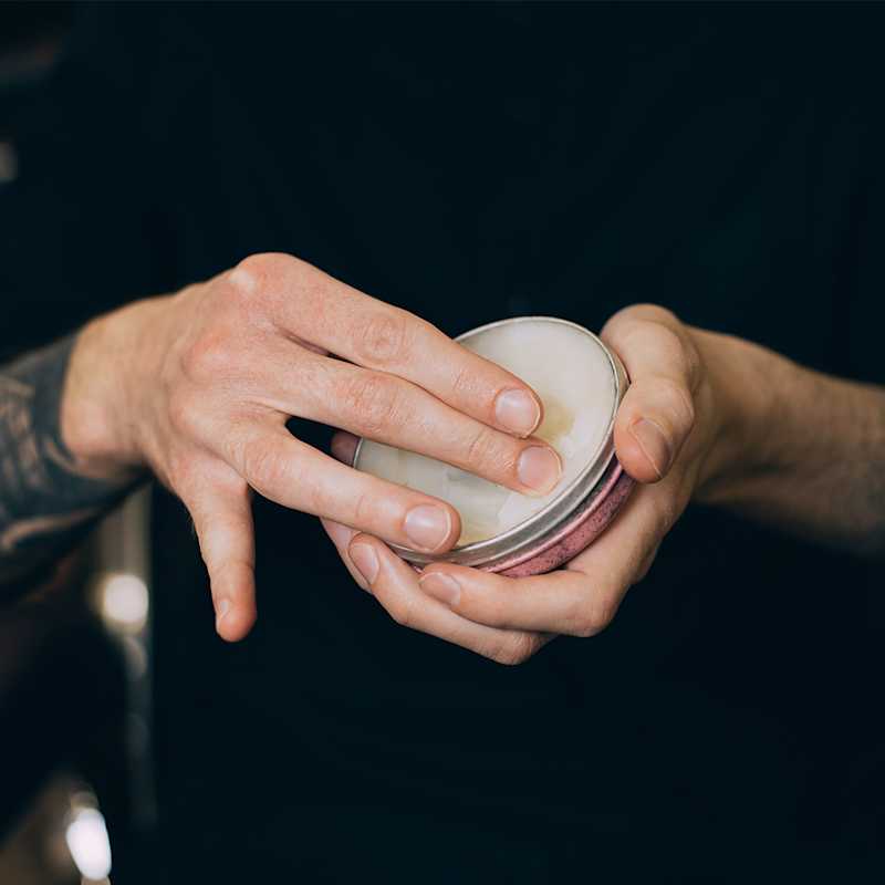 Mann mit Bartwachs in der Hand