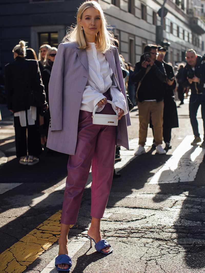 Frau trägt einen Blazer in der Farbe Flieder zu einer weißen Bluse und einer Chino in der Farbe Pink