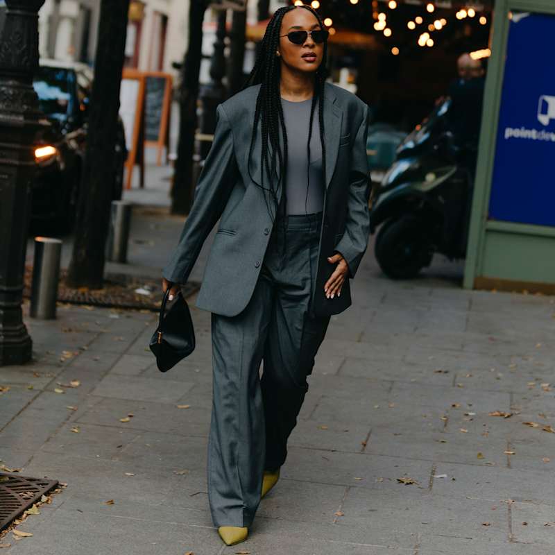 Frau trägt einen Hosenanzug in der Farbe Grau als monochromen Look