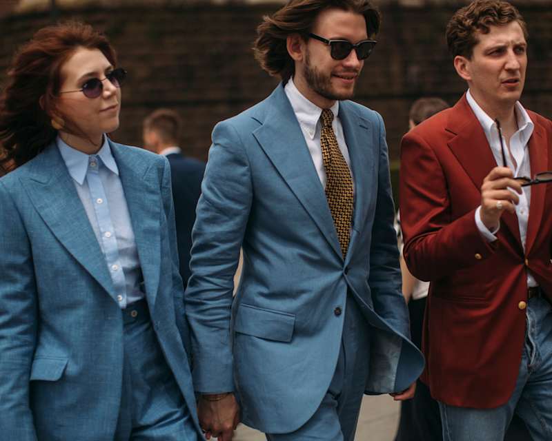 Eine Frau und zwei Männer tragen Outfits im Old Money Style