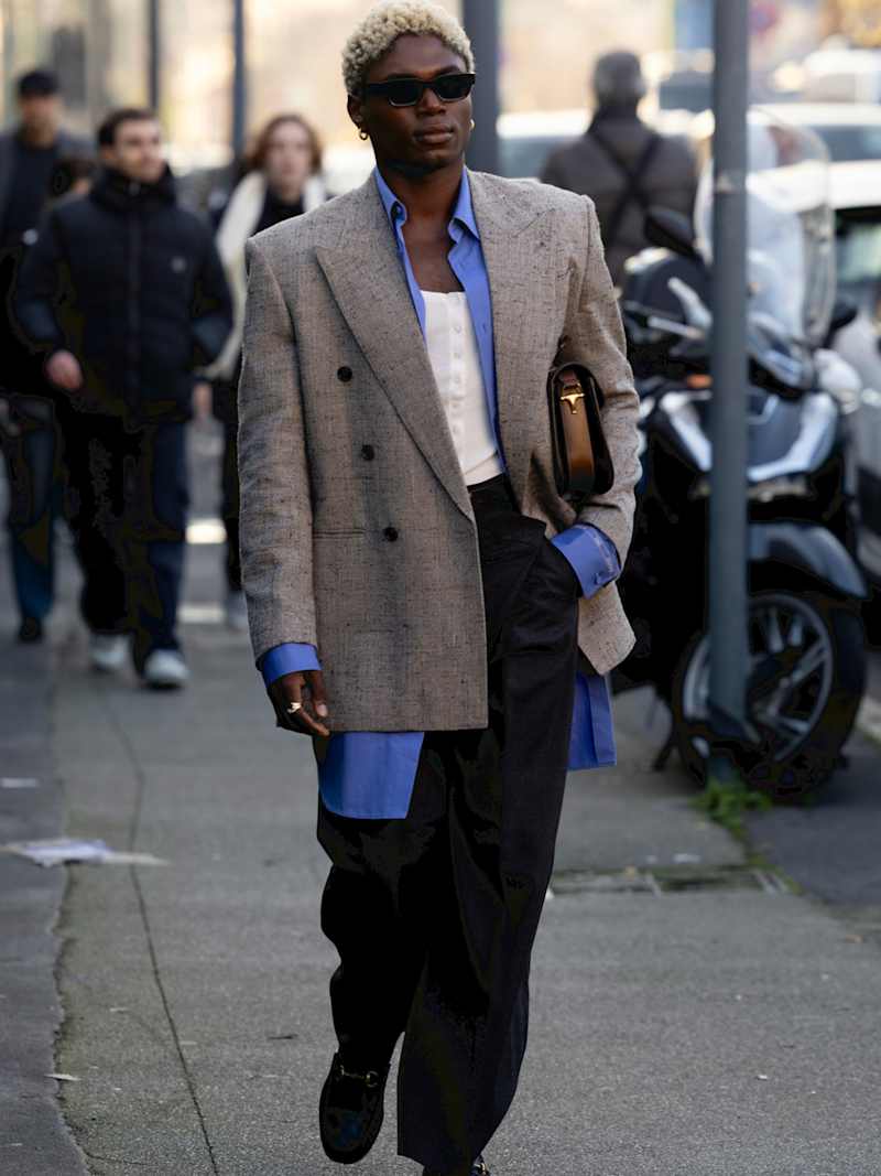 Mann trägt hellblaues Hemd, graues Sakko und dunkelblaue Stoffhose im Old Money Stil