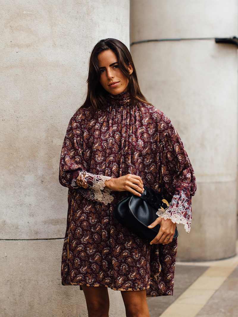 Frau trägt ein Midi-Kleid in Bordeauxrot mit Paisleymuste und Spitze im Boho-Style