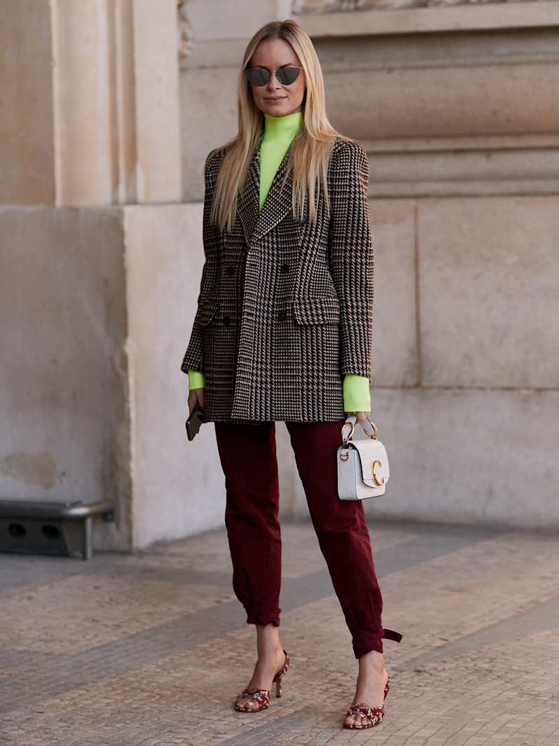 Frau trägt einen Blazer mit Glencheck-Muster zu einer roten Hose und Sandaletten 