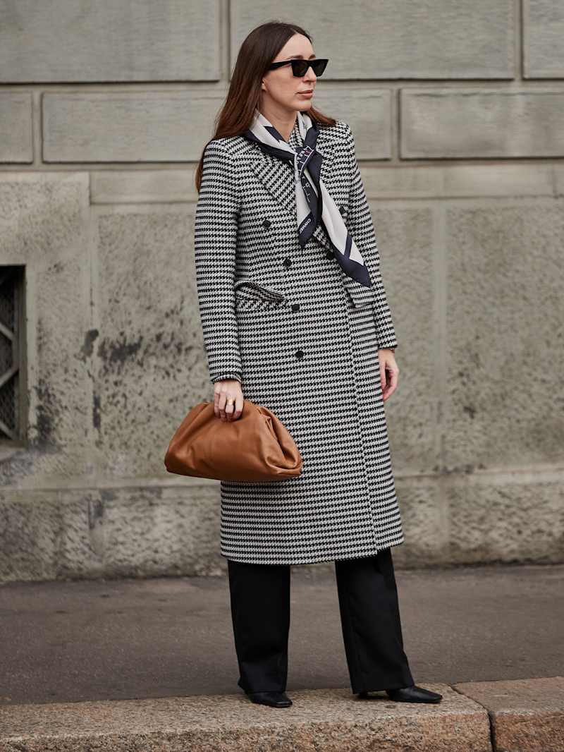Frau trägt schwarz-weißen Mantel mit Hahnentrittmuster