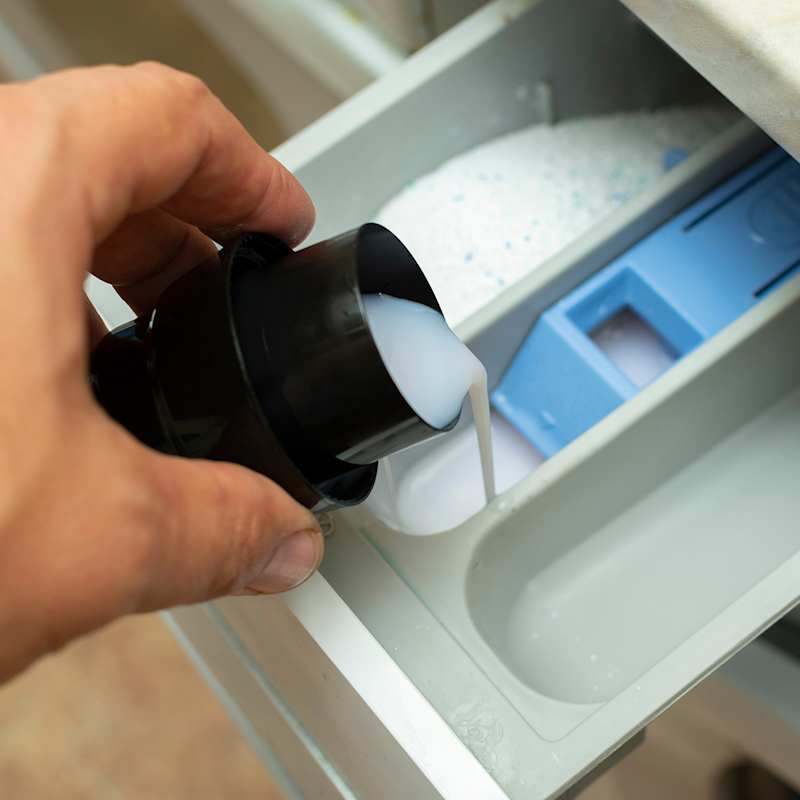 Weichspüler wird in die dazu vorgesehene Kammer einer Waschmaschine gefüllt