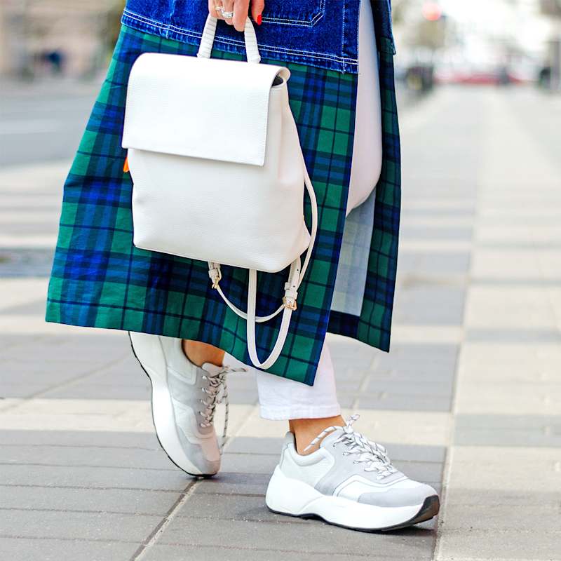 Frau trägt weiß-graue Sneaker mit weißer Plateau-Sohle