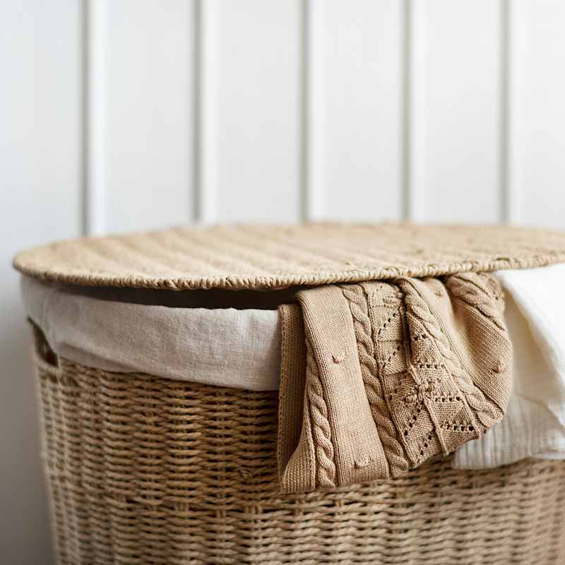Beiger Wäschekorb mit zwei Kleidungsstücken