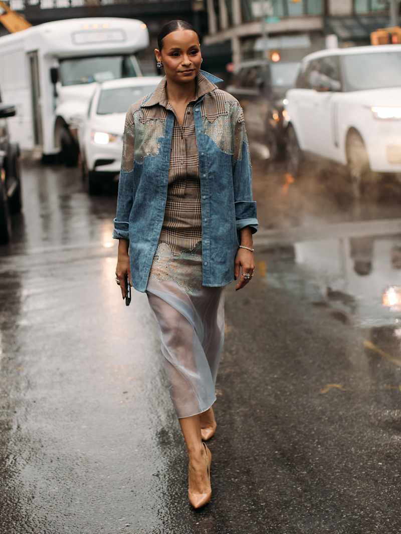 Frau trägt eine karierte Bluse und ein Jeanshemd mit Karomuster-Applikationen 