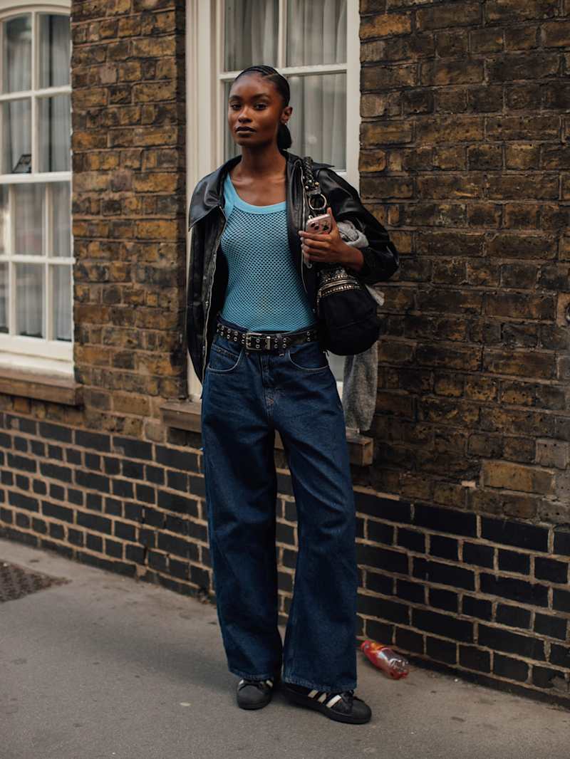 Frau trägt blaues Mesh-Tank-Top zu einer Releaxed Jeans und Biker-Lederjacke