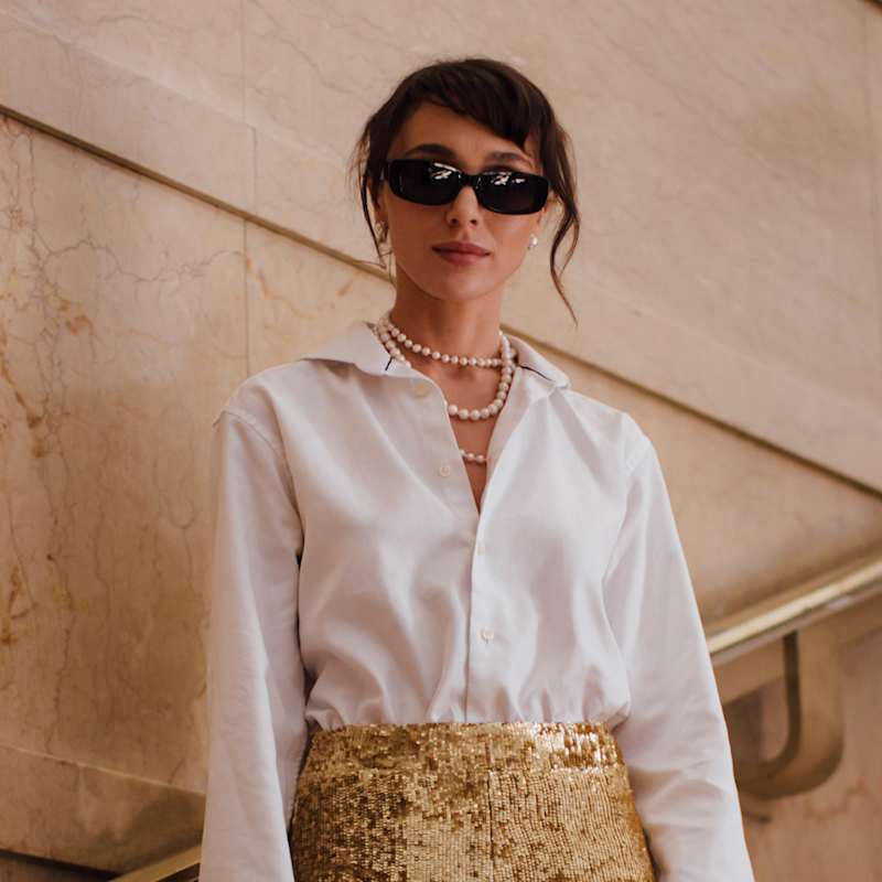 Brünette Frau mit zusammengebundenen Haaren und seitlichem Pony