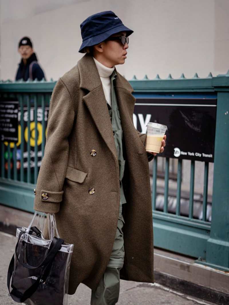 Mann, der einen schwarzen Bucket Hat als Utility Wear trägt, kombiniert den funktionalen Kleidungsstil