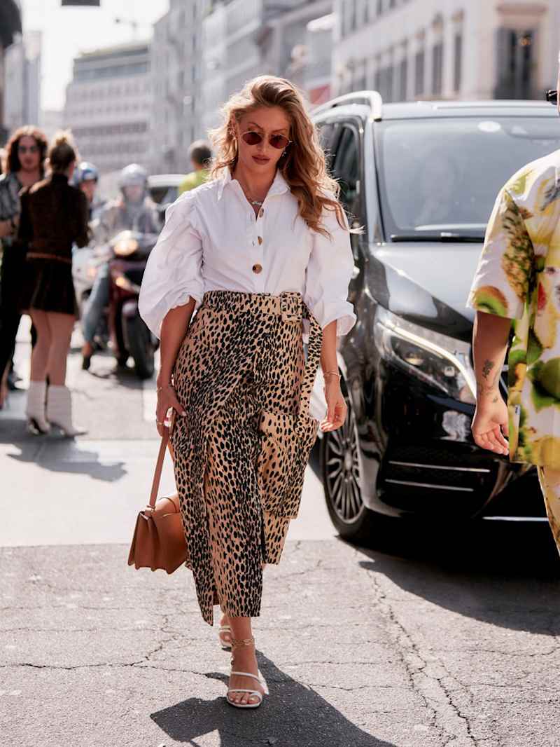 Frau trägt weiße Bluse zu einem Rock mit Leo-Muster