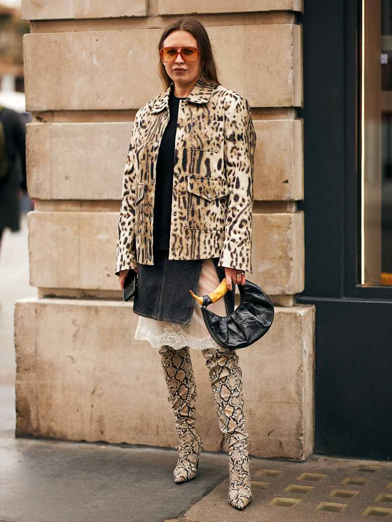 Frau trägt Leopardenmuster-Jacke und Overknees mit Snake Print