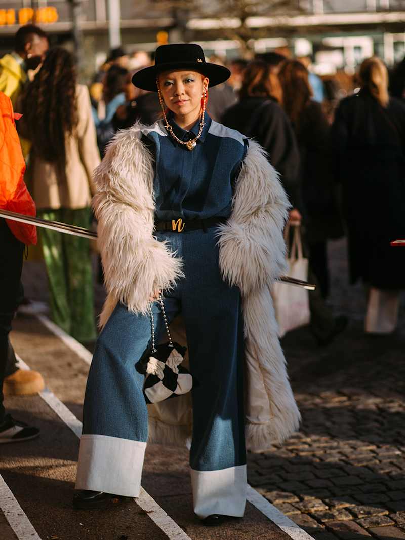 Frau trägt einen Jeans-Allover-Look mit einem Fellmantel