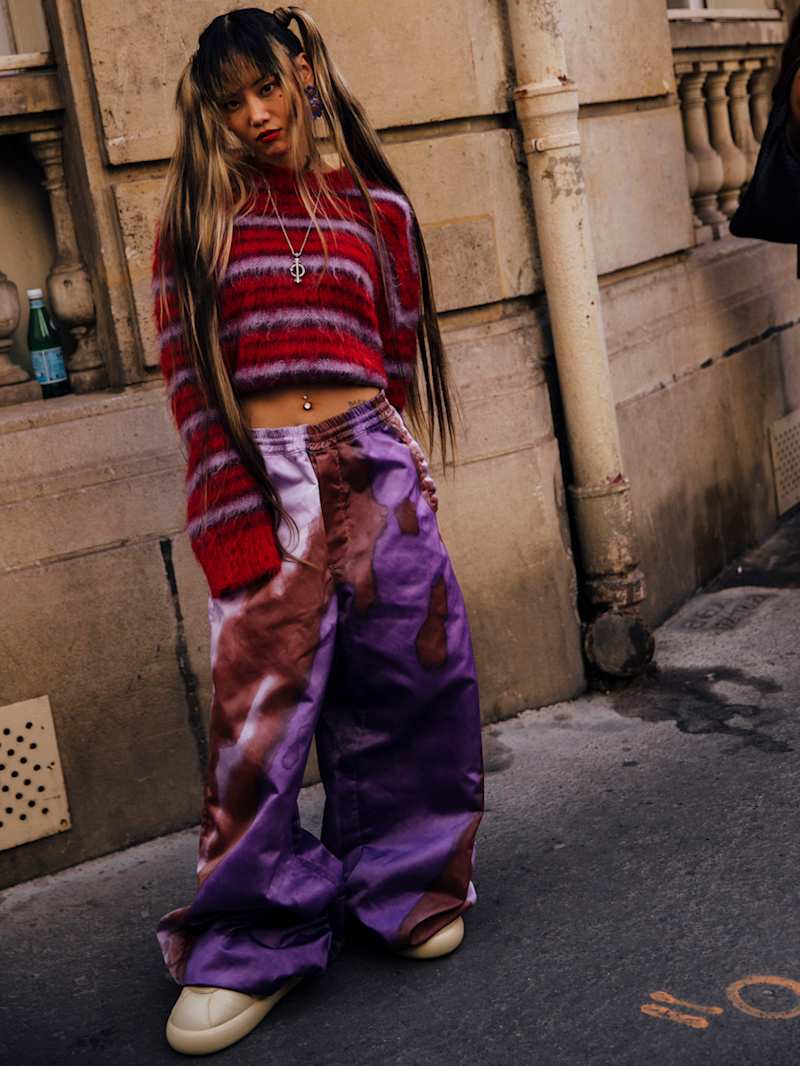 Frau trägt ein Cropped-Top zu einer weiten Hose mit Batikmuster