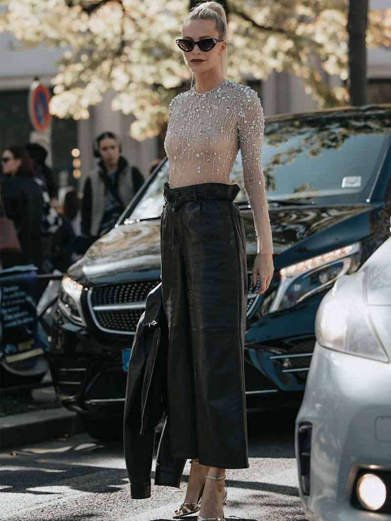 Frau trägt eine schwarze Leder-Culotte mit einem Glitzer-Body 