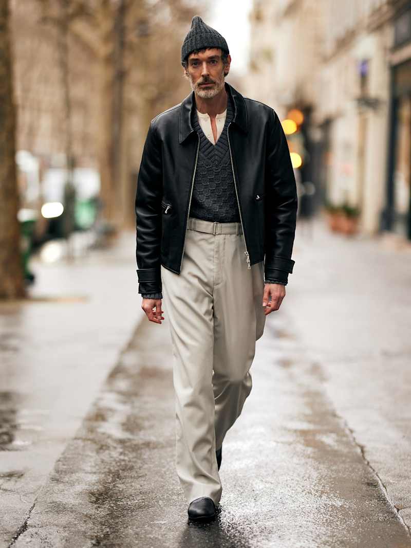 Mann trägt als Teil der neuen Herbstgarderobe einen schwarzen Blouson aus weichem Leder zur einer hellgrauen Stoffhose