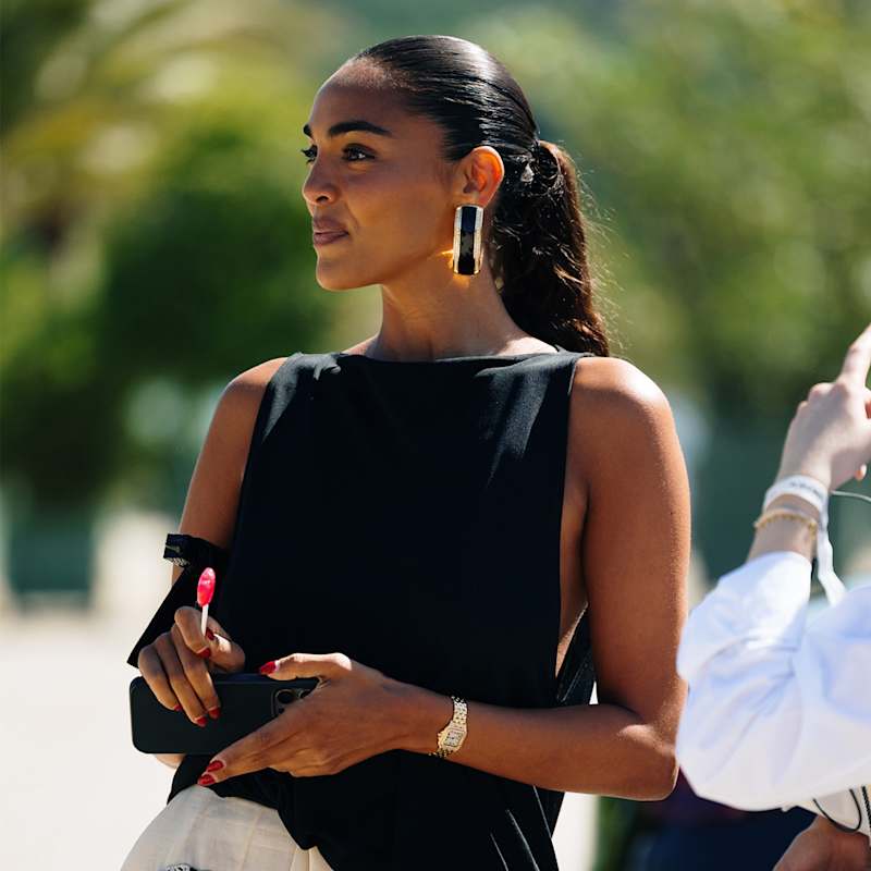 Frau trägt ihre dunkelbraunen Haare in einem hohen Sleek-Pferdeschwanz