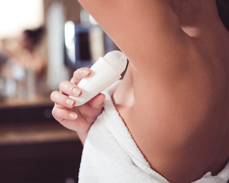 Frau trägt nach dem Duschen Deodorant auf