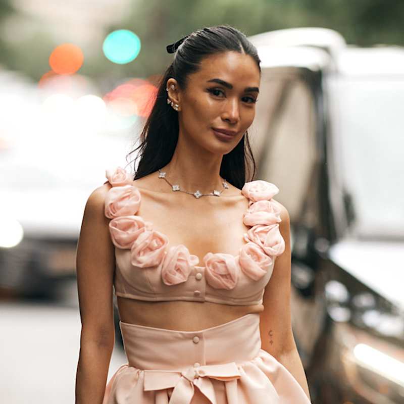 Frau trägt ihre schwarzen Haare in einer Half Up-Variante