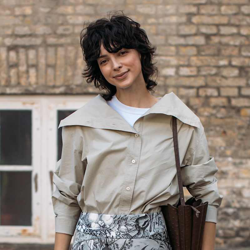 Frau mit dunkelbraunen Haaren trägt einen Curly Mullet