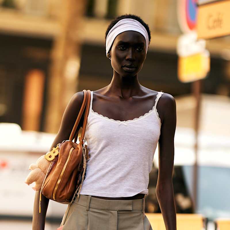Frau trägt ihre schwarzen, kurzen Haare mit einem Haarband aus dem Gesicht