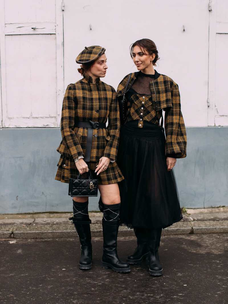 Zwei Frauen tragen Winter-Outfits mit Karomuster 