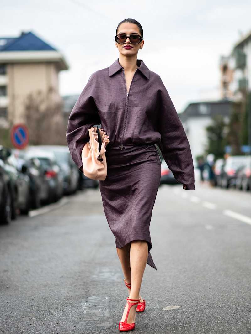 Frau trägt einen Blouson und einen Rock in der Winter-Trendfarbe Mauve